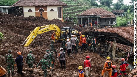 Rescue teams search for victims buried by landslides in Cihanjuang Village, West Java. 