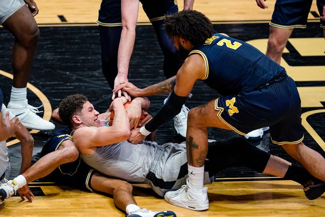 Purdue forward Mason Gillis and Michigan striker Isaiah Leavers try to get the ball during the second half in West Lafayette, Indiana, Friday, Jan.22, 2021.