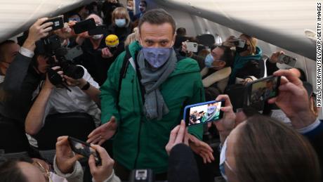 Passengers and journalists take pictures of Alexei Navalny seated in his plane seat on Sunday.