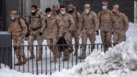 Members of the military walk through the snow in central Madrid, Spain, Sunday 10 January.